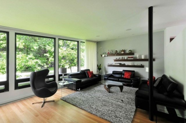 Polička na stenu do obývačky s čiernym koženým nábytkom a sivým kobercom Nápady na úsporu miesta na stene z koženého nábytku v sivom koberci