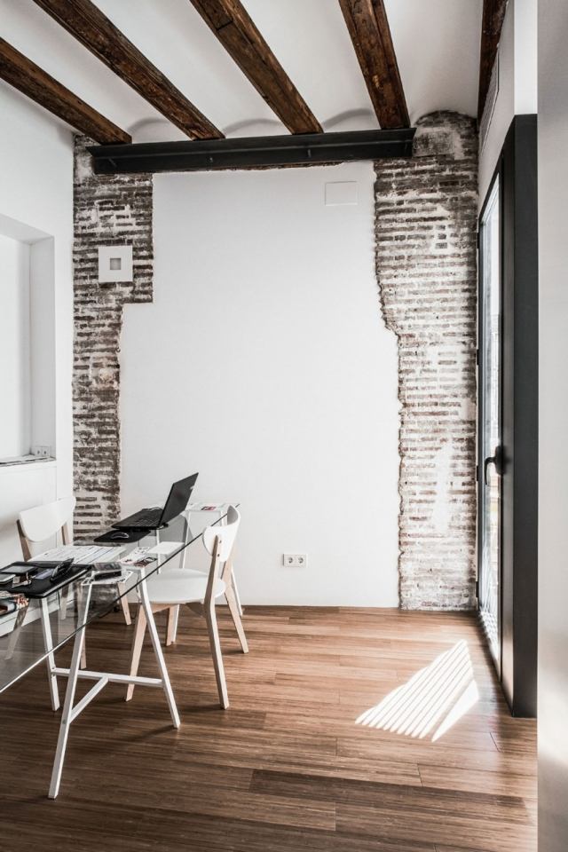 drevená podlaha stôl z tmavého skla viditeľný krokvy