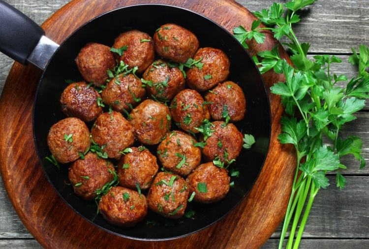 Mleté knedle na panvici posypané petržlenovou vňaťou Kombinácia jedál-recepty-mleté-mäsové guľky-zlatisto-hnedá-doska na krájanie-proteín-obsahujúca-petržlenová vňať