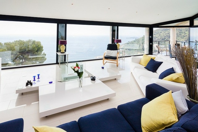 Biely nízky konferenčný stolík v obývačke Vzhľad biely nízky konferenčný stolík žltý dekoračný vankúš tmavomodrá pohovka