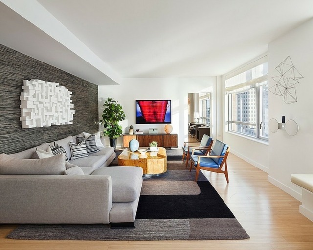 Obývacia izba zariadená dizajnovým kobercom na stenu Rohová sedacia súprava s laminátovou podlahou z kamennej steny a rohovou pohovkou