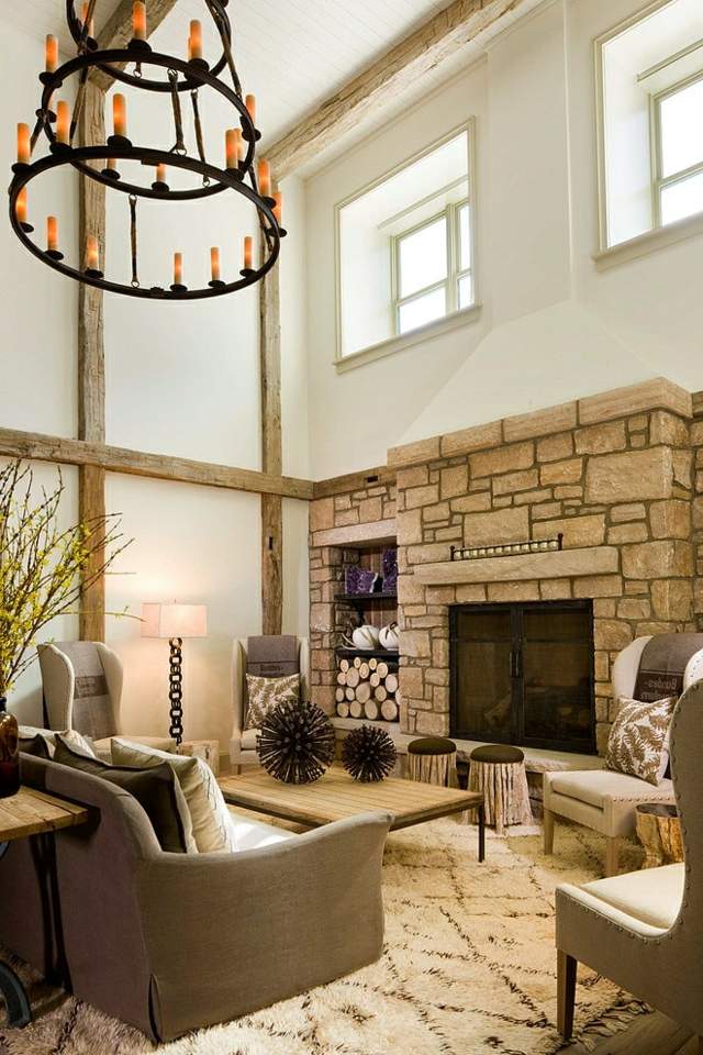 Obývacia izba s vysokými stropmi, krbom obloženým kameňom a rustikálnym nábytkom rustikálne nápady domov obývačka kamenná stena krb klasický nábytok dizajn koberec luster