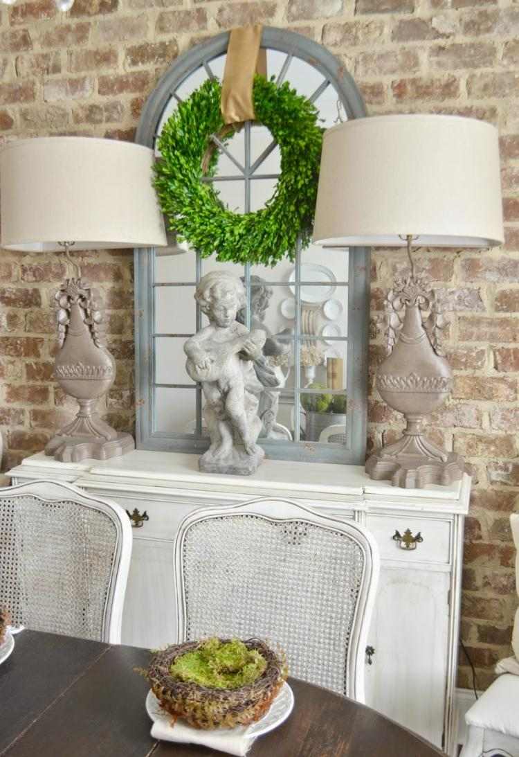 staré alebo zámerne zastarané položky a čerstvé zelené konáre rustikálne-jarné-dekorácie-nápady-stolná-dekorácia-biela-stolná-lampa-veniec-zimostráz-zrkadlo