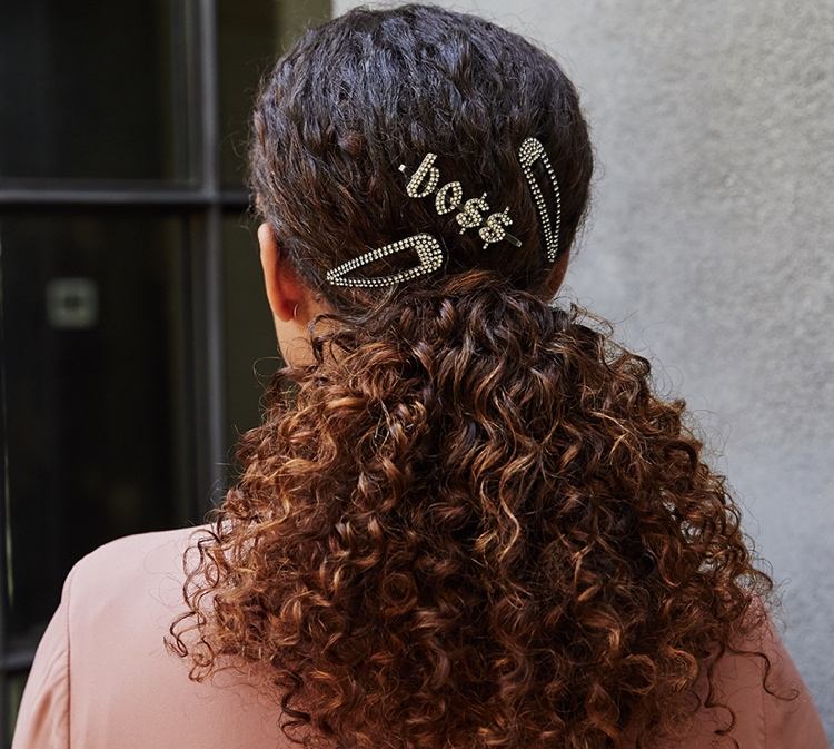 prírodné kučery zviazané do chvosta so sponami do vlasov