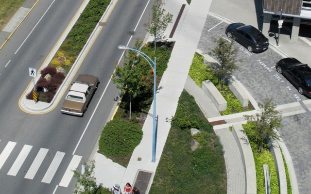 Záhradná betónová lavička okrasné stromy dlažba trávy