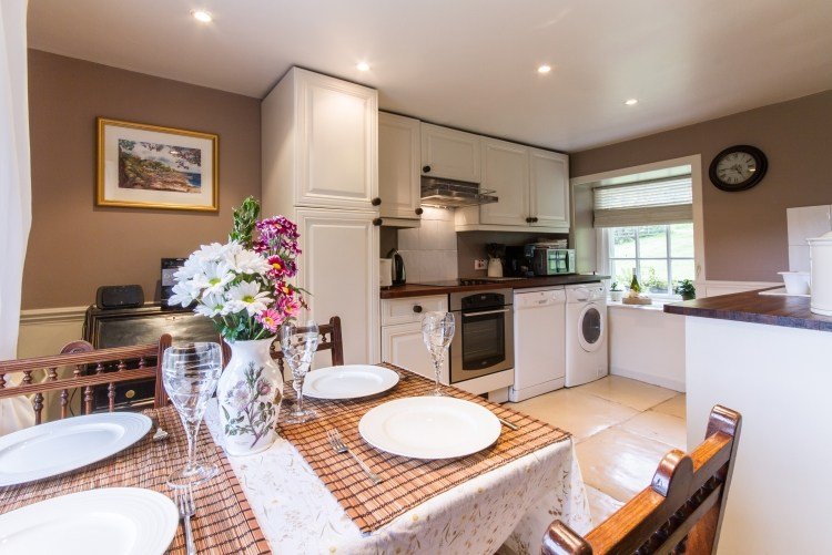 otvorená kuchyňa a jedálenský kút v bielych a béžových stenách moderný-práčovňa-kuchyňa-otvorená-kuchyňa-biela-stena-farba-béžová-jedálenský stôl