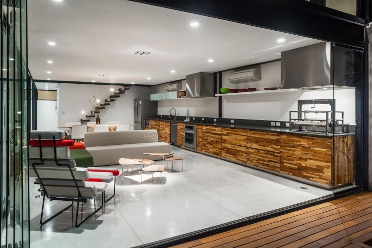 otvorená kuchyňa a obývačka v sivých tónoch a skrinky s drevenými prednými časťami Nápady na vybavenie-obývačka-otvorená-kuchyňa-nerez-drevo-škvrny-plávajúce-schody-kachľové-sedenie