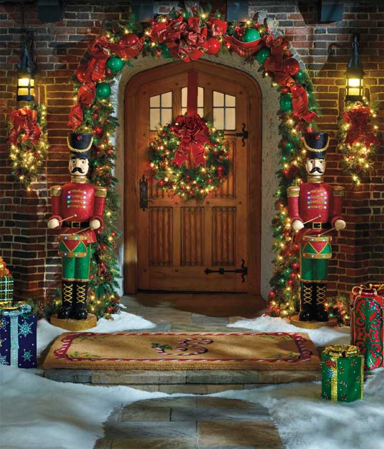 vianočné dekorácie s jedľovými girlandami vchodové dvere darček luskáčik