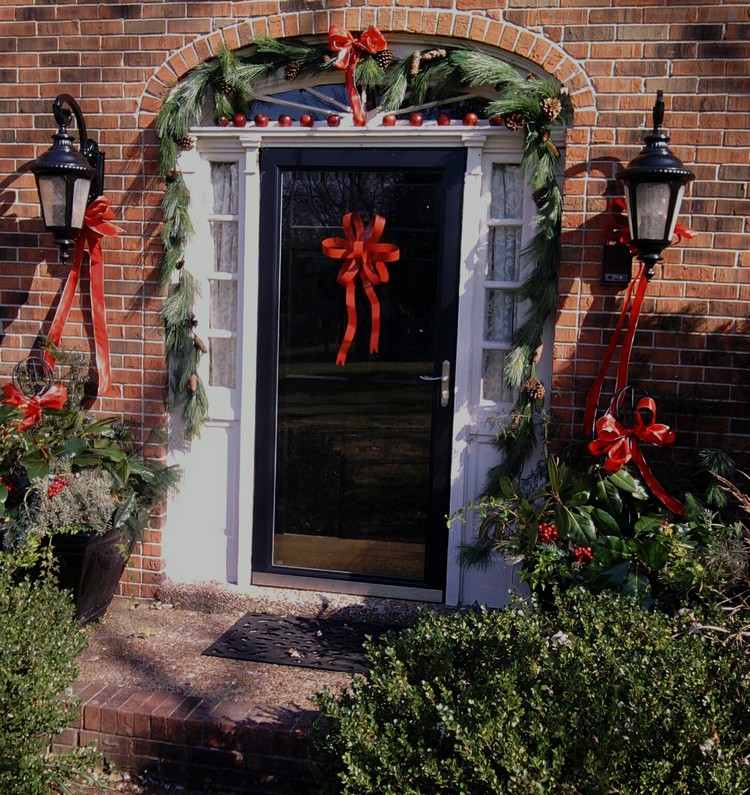 Vianočná dekorácia s vchodom do domu z jedľových girlandov-červené stužky