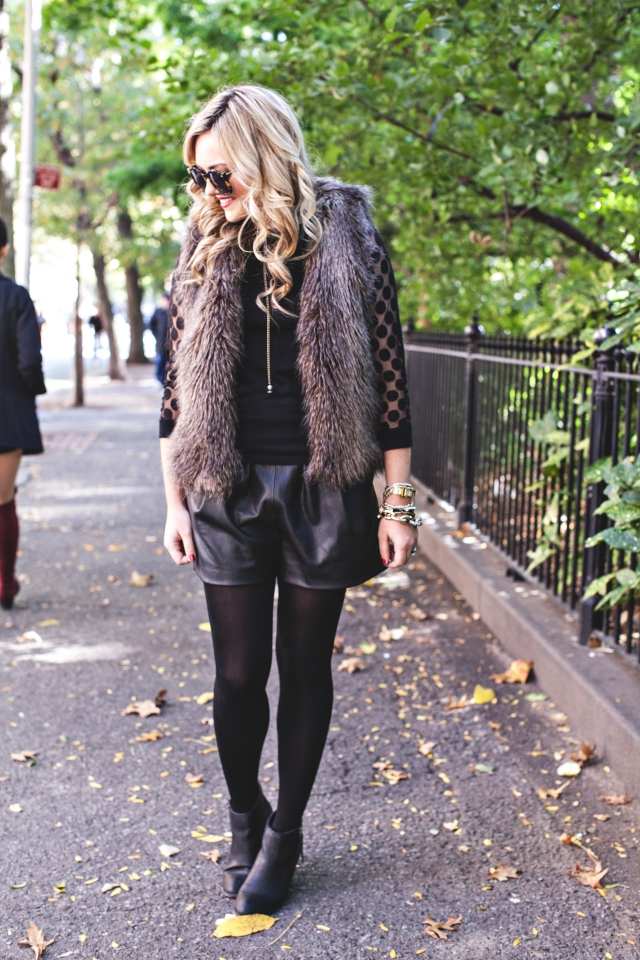 Outfity s kožušinovou vestou jeseň-čierno-kožené šortky-čižmy