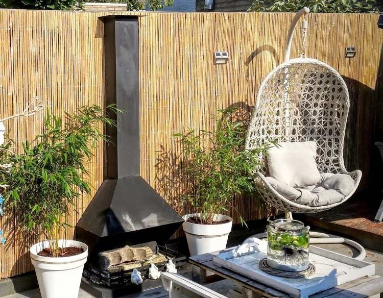 Bambusové podložky ako bezpečnostná ochrana s krbom a závesnou stoličkou na terase