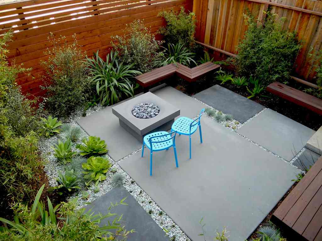 Terasa s veľkými betónovými platňami a štrkom a drevenými zástenami