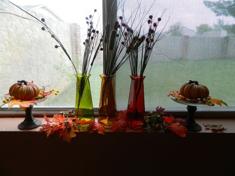 Jesenná dekorácia parapetu s umelým lístím deco okenný parapet jesenné farby zelená oranžová červená vázy tekvicové listy