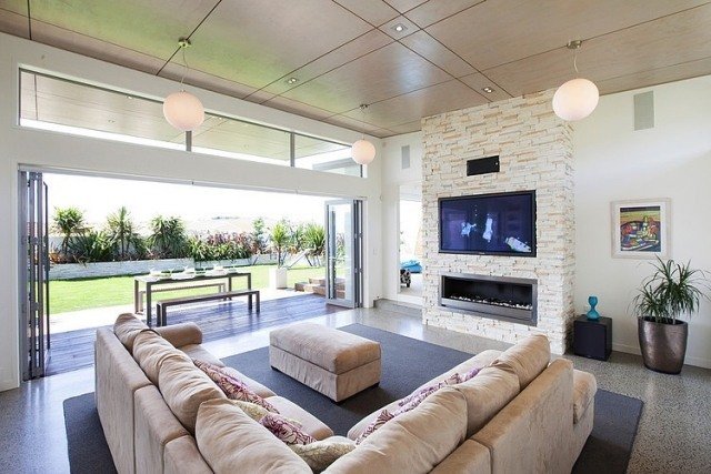 Rohová sedačka v obývacej izbe s jemnými béžovými tónmi, v ktorej sa vďaka krbu budete cítiť príjemne obývačka-posuvné dvere-útulná-rohová-sedačka-čalúnenie-vstavaná-krb-led-obrazovka