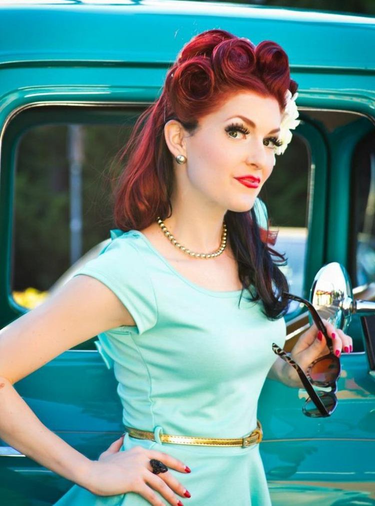 Účes z pootvorených, červeno-čiernych vlasov s pin-up kučerami účesy rockabilly rockabilly účesy ryšavé vlasy kvetinové šaty svetlo modré