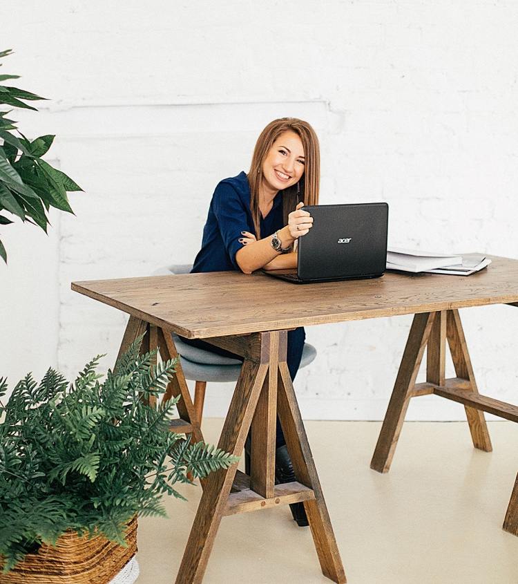 Stôl z masívu a zelené rastliny v udržateľnej domácej kancelárii