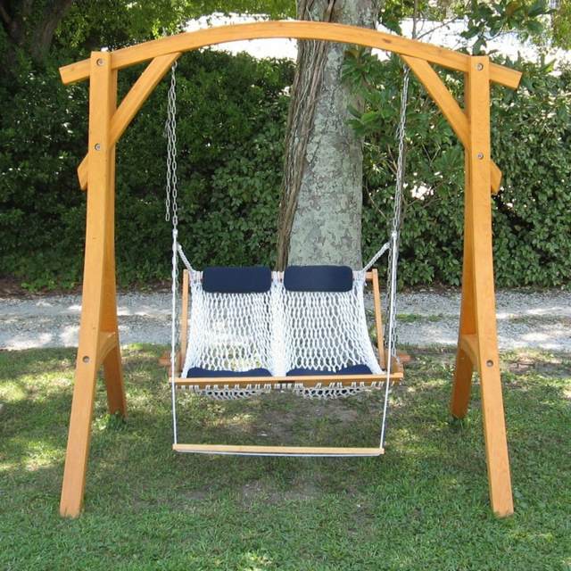 Hojdačka v záhrade s dreveným rámom a trávnikom