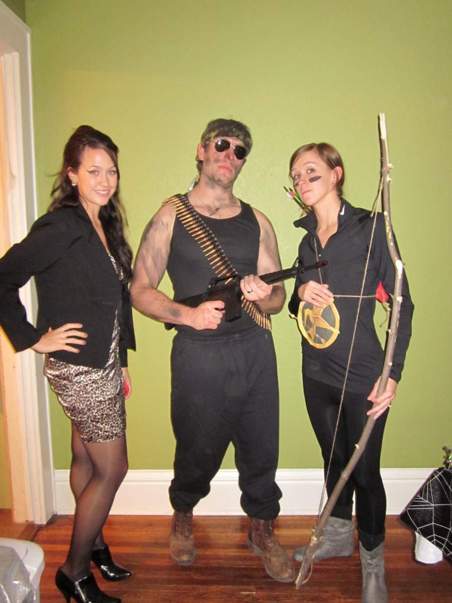 muž a dve ženy kostýmované ako john rambo s lukmi a nábojmi