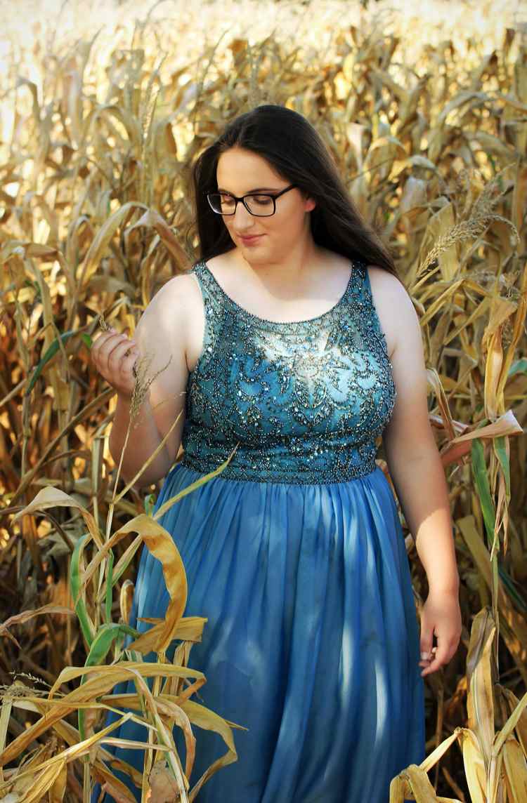 Bacuľatá žena v modrých večerných šatách s perleťovým vyšívaným topom