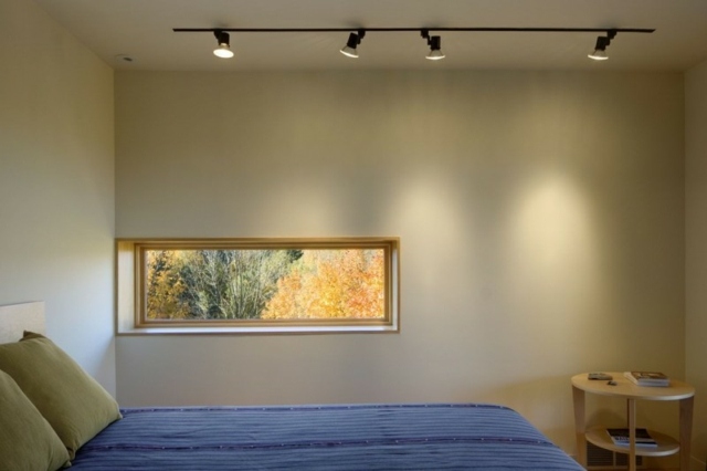 Spálňa zariadená puristicky okenným dreveným stolom s manželskou posteľou rozložiť okno drevený stôl manželská posteľ nastavená puristicky