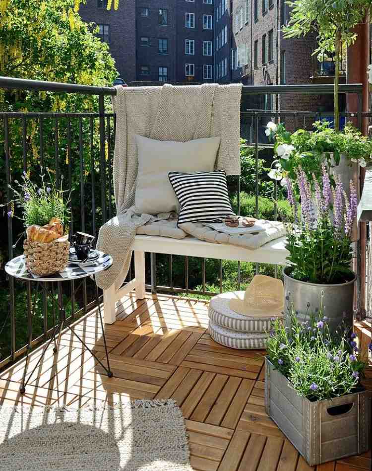 Vytvorte si útulný kútik na balkóne s vankúšmi a prikrývkami balkón-obklady-drevená-lavica-kovové zábradlie-levanduľa-kvetináč-deka-vankúše