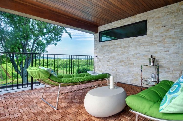 moderné a útulné aj vo vonkajšej časti s múrom z prírodného kameňa a drevenou podlahou balkón-dlažba-drevo-prírodný kameň-stena-moderné-sedenie-čalúnenie-vankúše-vonkajšie-zelené