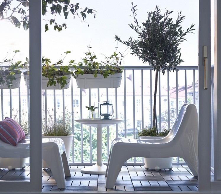 Navrhnite balkón v bielej farbe a ozdobte ho zelenými rastlinami balkón-dlažba-drevo-moderné-biele-plast-stoličky-stôl-kovové zábradlie-olivovník