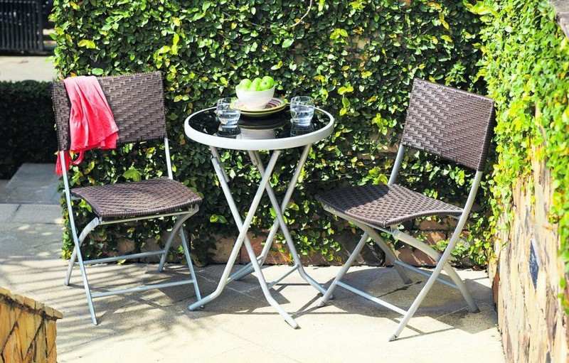 Okrúhly stôl a dve skladacie ratanové stoličky na balkóne Balkónový nábytok na malé balkóny Ratanový okrúhly stôl so skríženými nohami