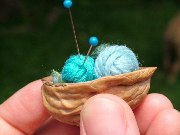 drotár s prírodným materiálom škrupina z orechov, ihly, nite, rolky, modrá, slimák