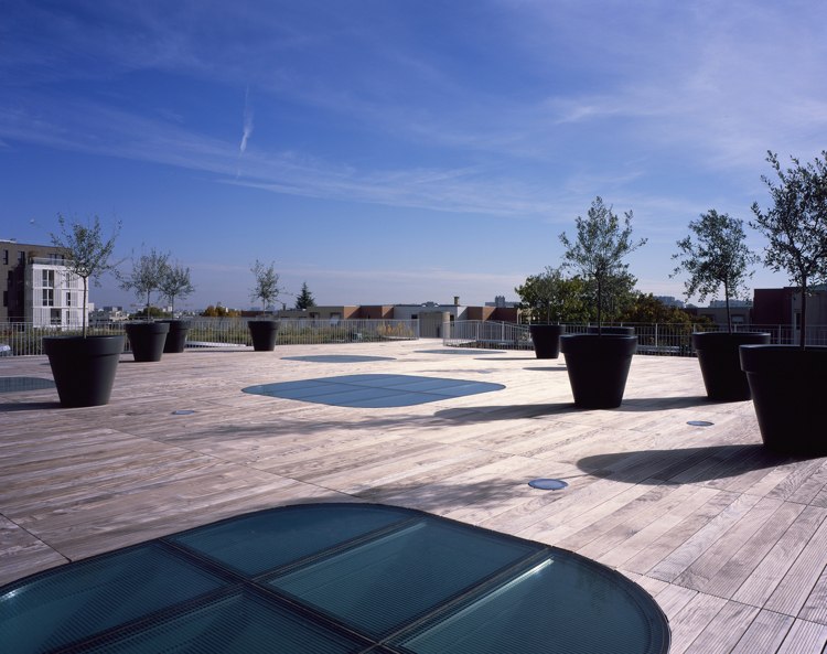 Sklenená strešná terasa strechy bazéna presvetľuje malé stromy v kvetináčoch