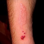 Fehér tetoválás - toll és vér a karon