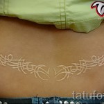 Fehér tetoválás - minta a hát alsó részén