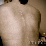 fehér tetoválás - fotó felirat a gerincen