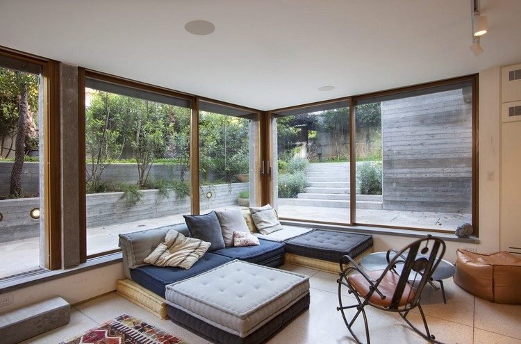 presvetlené obývačky presklené steny výhľad na betónové steny terasy vonku