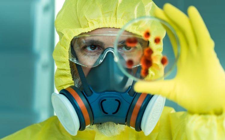 Muž s ochranným odevom, ktorý v čase vypuknutia Číny drží vzorku s bubonickým morom, nepredstavuje žiadne nebezpečenstvo