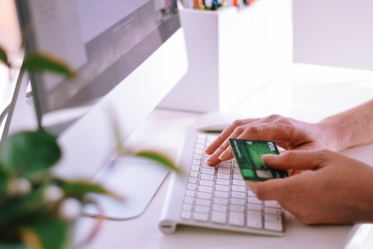žena objednávajúca online na počítači s kreditnou kartou platiacou za dištanc od spoločnosti