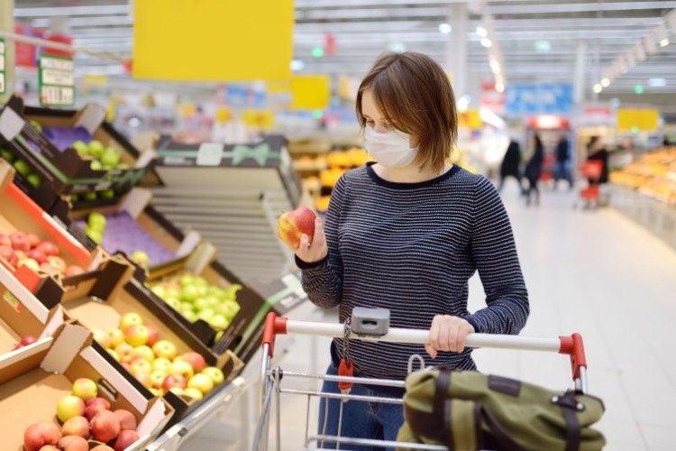 žena v ochrannej maske pri nákupe v supermarkete kvôli koronavírusu