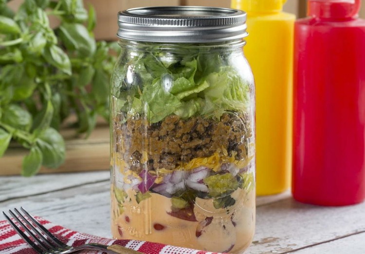 Šalát Big Mac podávaný v murárskej nádobe big-mac-šalát-jar-vrstvené-dresingy-kyslé uhorky-cibuľa-mleté mäso-ľadový šalát-vidlička