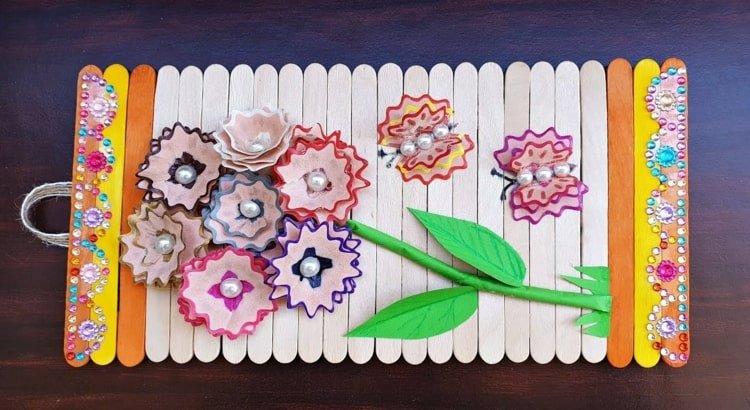 Drevené obrázky vyrobené deťmi - bežcami vyrobenými z paličiek od nanuku a kvetmi z drevených hoblín