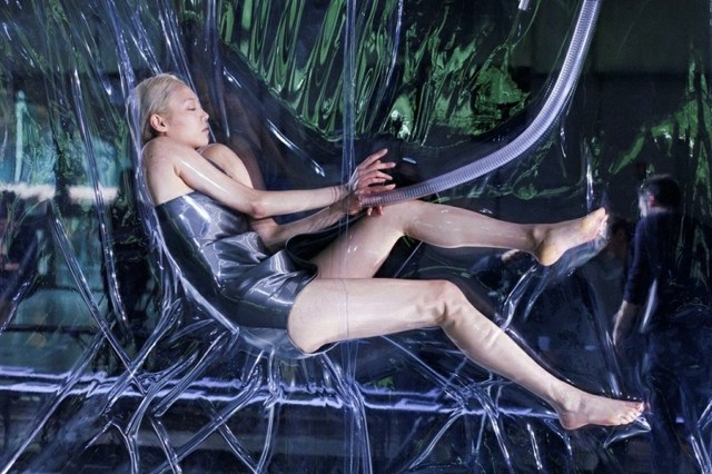 Modelka v krátkych šatách ako embryo v maternici Kolekcia IIris van Herpen