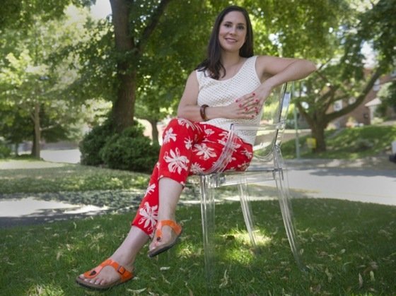 Patent na červené sandále Birkenstock Žena na stoličke v záhrade s červenými nohavicami s kvetinovými vzormi a Birkenstocks