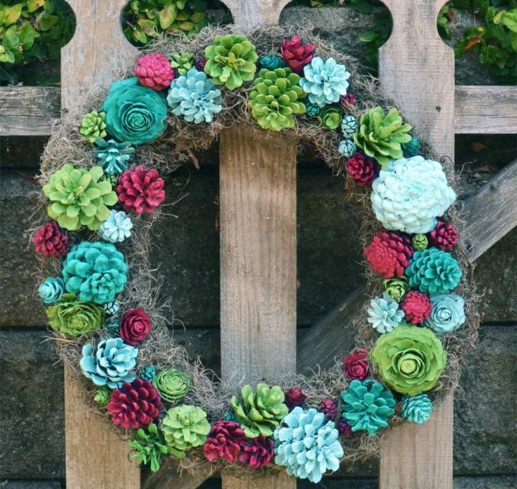 Machový veniec s kvetmi vyrobený z borovicových šišiek ako záhradná dekorácia na jar a na jeseň
