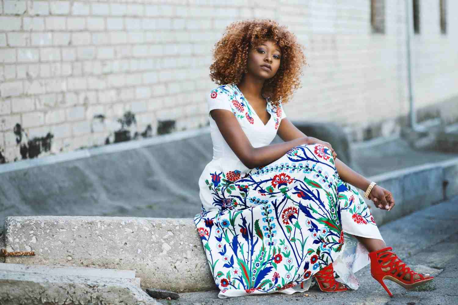 Šaty s kvetinovým vzorom kombinujú červené sandále na vysokom podpätku s módnymi trendmi pre ženy