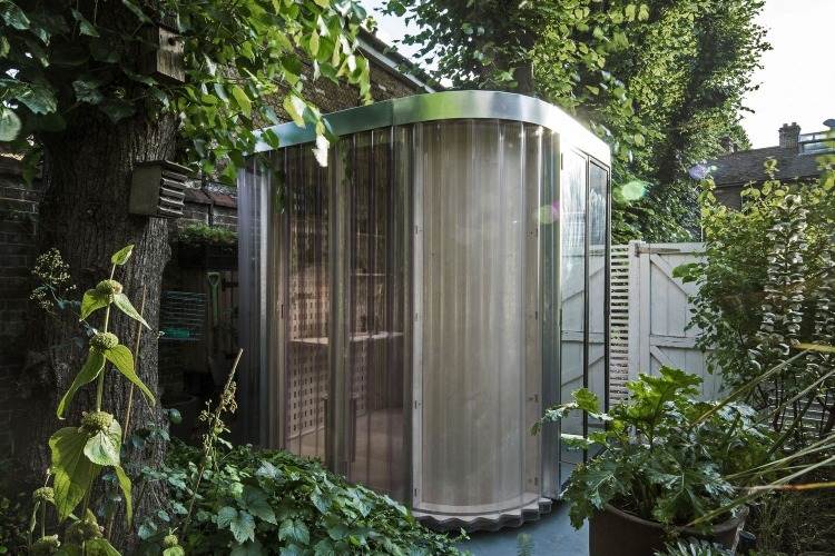 kója ako kancelária v záhrade s priesvitnými stenami a dreveným nábytkom v minimalistickom dizajne