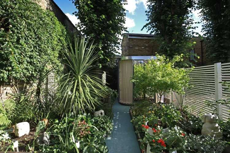 samostatný montovaný dom ako kancelária v záhrade so sklenenými dverami a stenami v tvare vlny z polykarbonátu