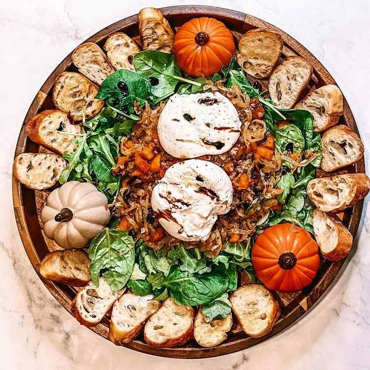 Jesenný tanier burrata na okrúhlom drevenom podnose