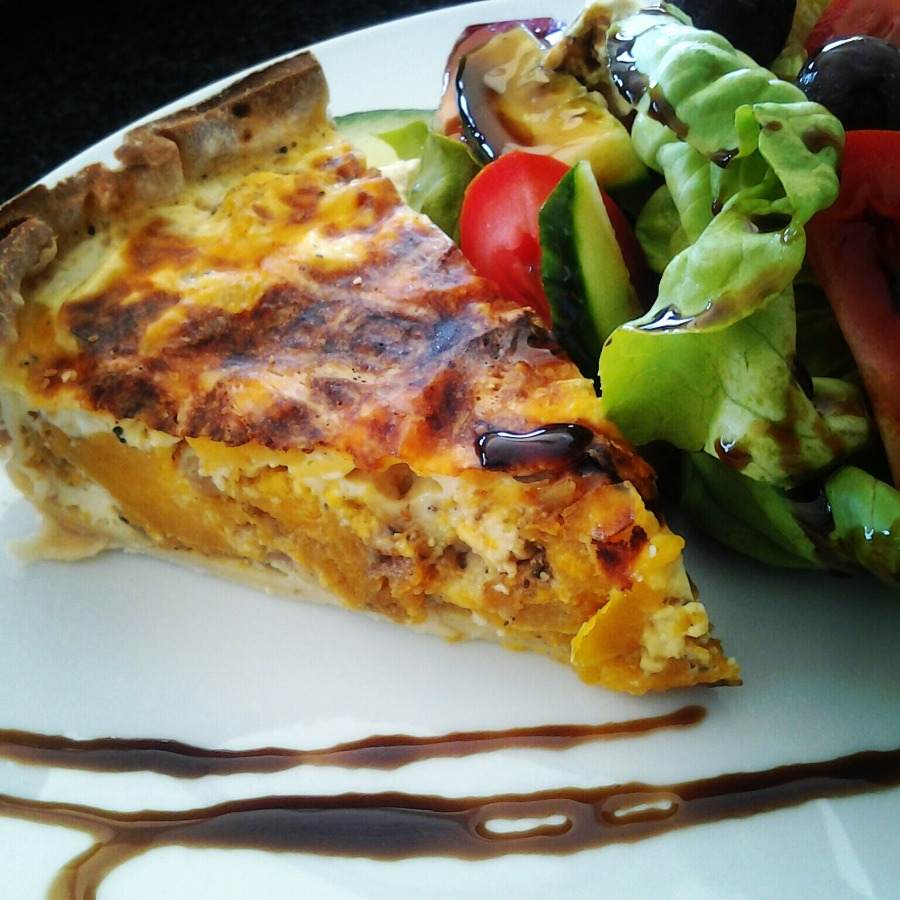 trojuholníkový kúsok quiche podávaný ako recept na tekvicovú tekvicu s prílohovým šalátom a balzamikovým octom