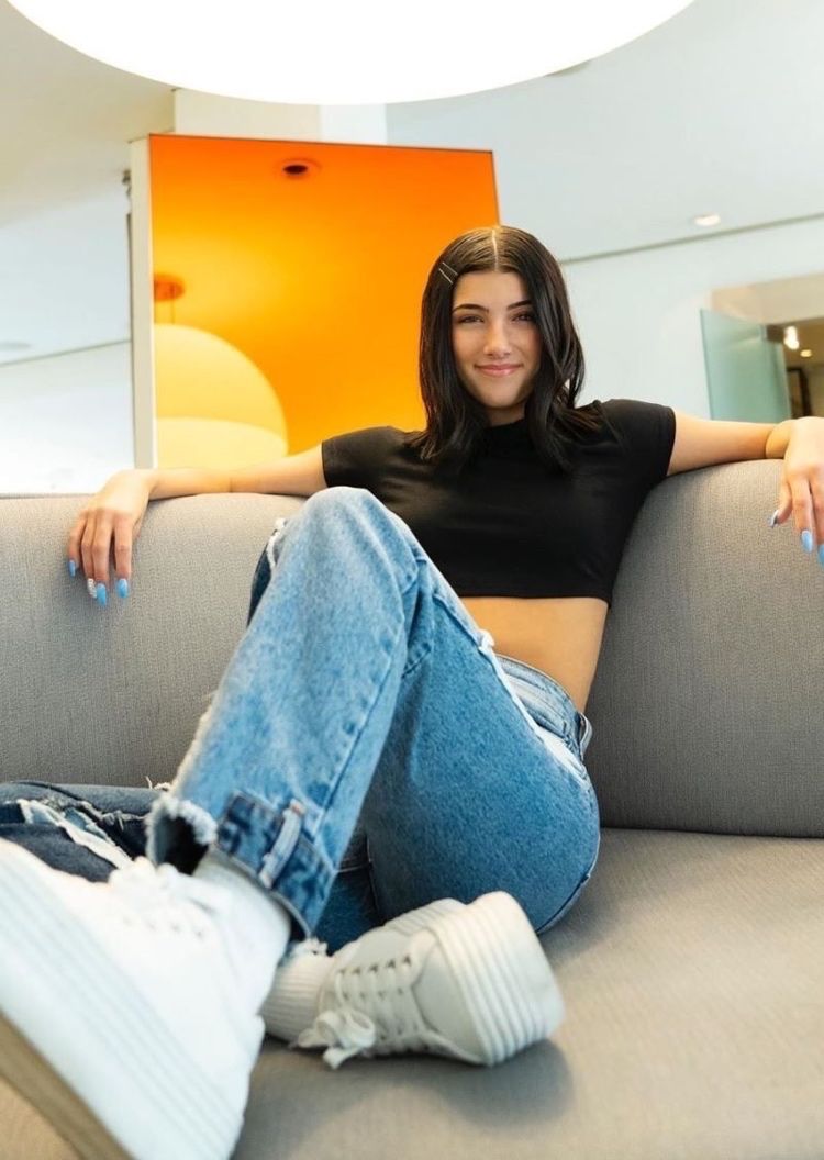 Charli D'Amelio v každodennom vzhľade s teniskami, crop topom a džínsami