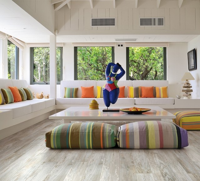 Dláždená podlaha v drevenom vzhľade-moderná obývacia izba zdobená farebnými vankúšmi Obývacia izba-nápady-sedacia súprava-farebné-vankúše-pruhy-dlažba-cerdomus