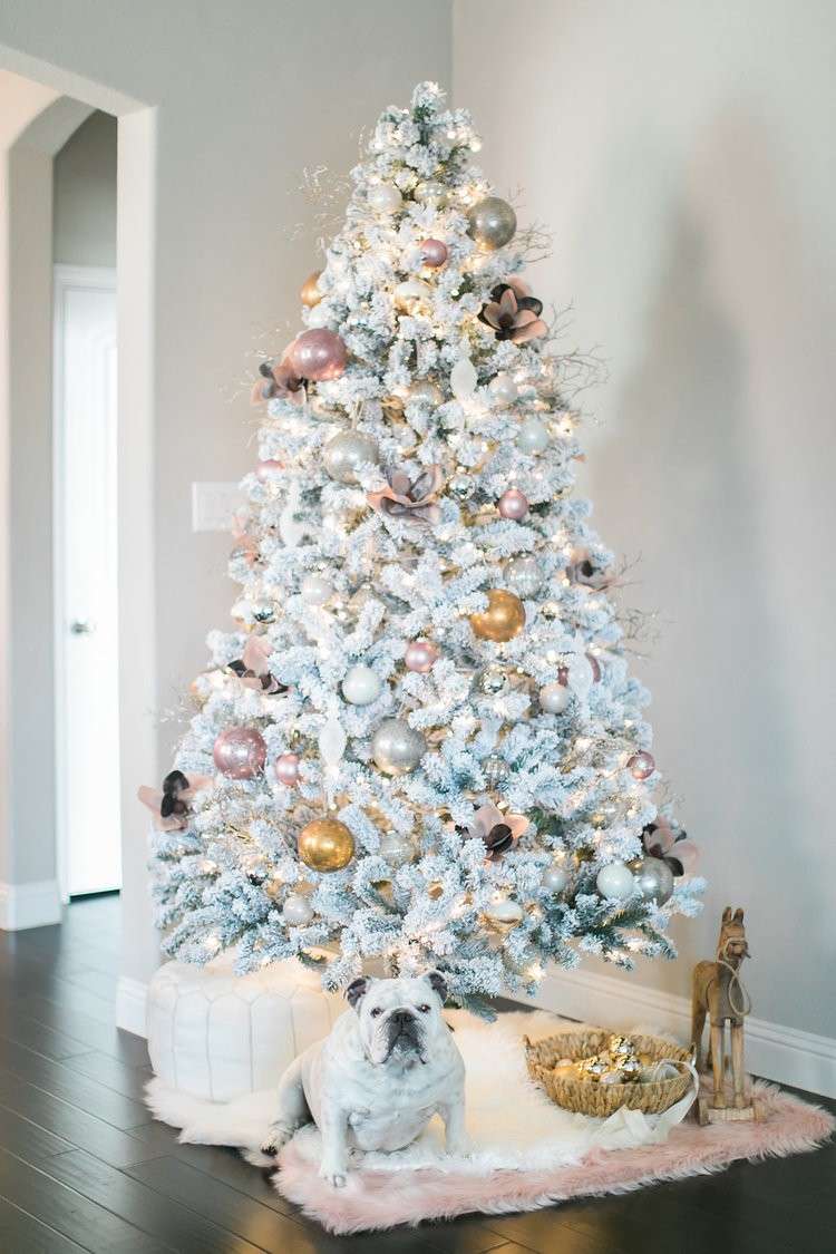 Vianočný stromček s umelým snehom zdobí ružové zlaté rozprávkové svetlá